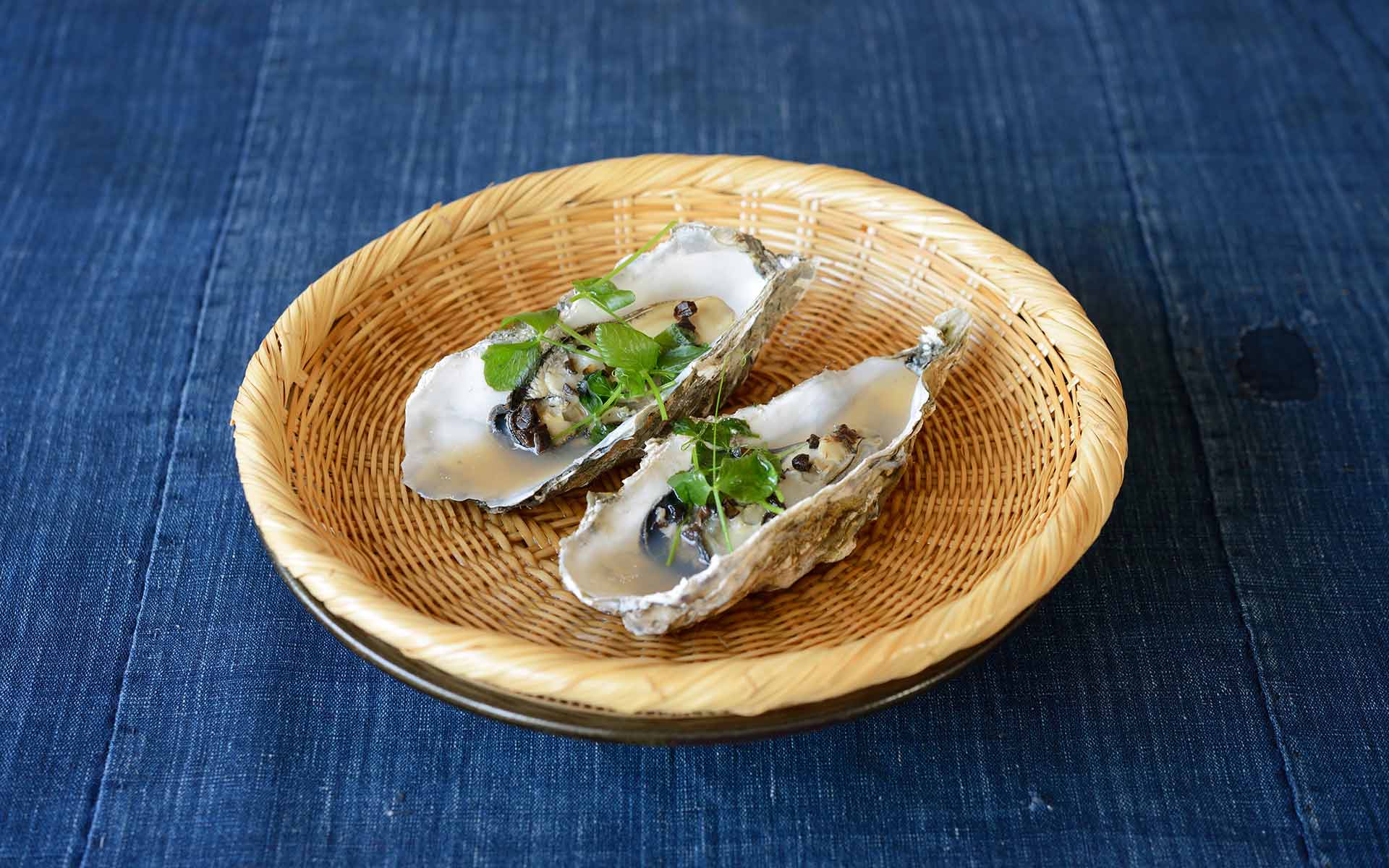 竹ザルの上の蒸し牡蠣