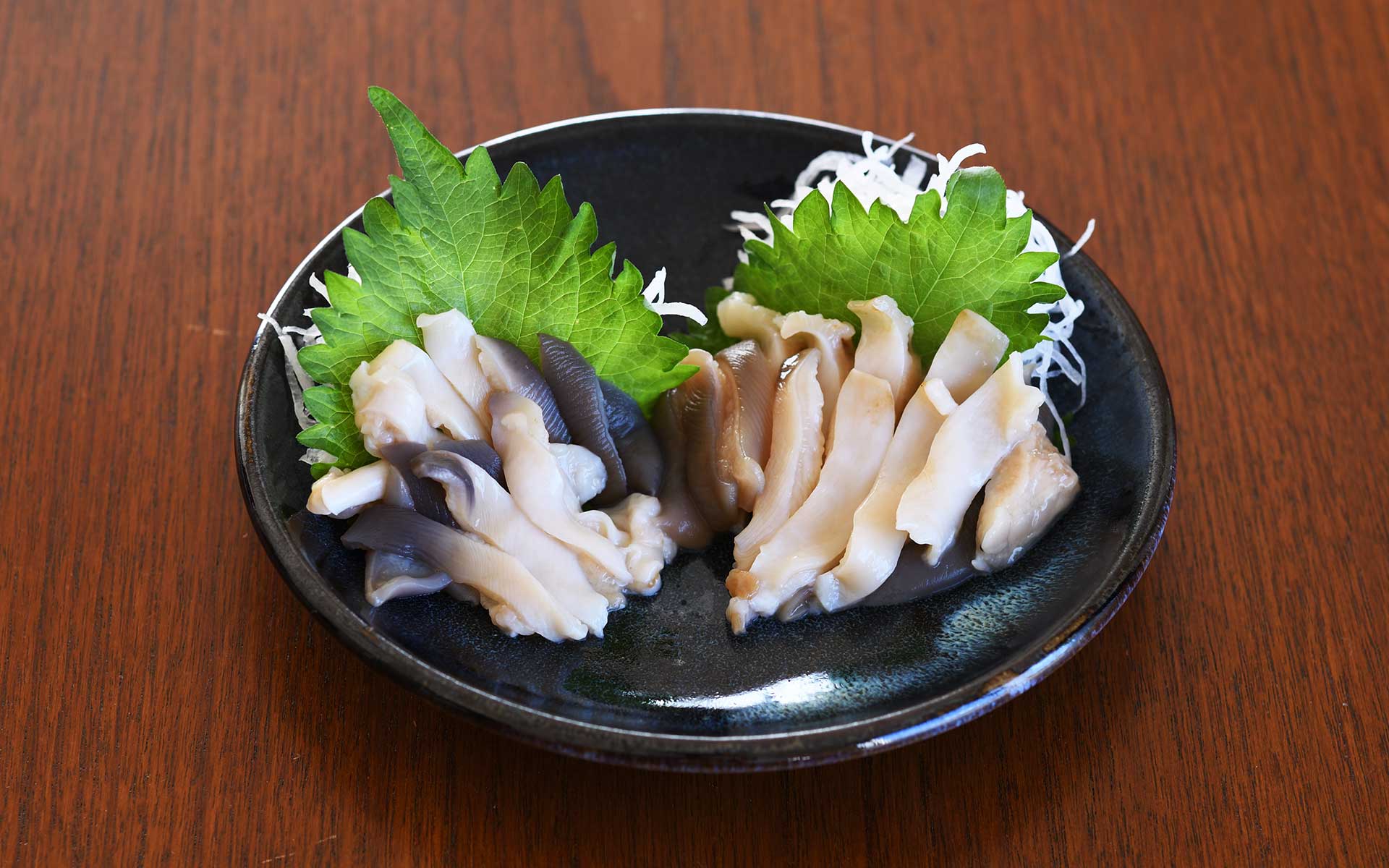 ホッキ貝の刺身をうつわに盛り付ける